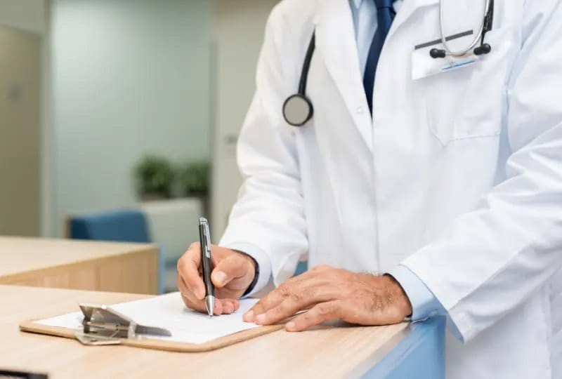 Médecin du travail annotant un dossier lors d'une consultation