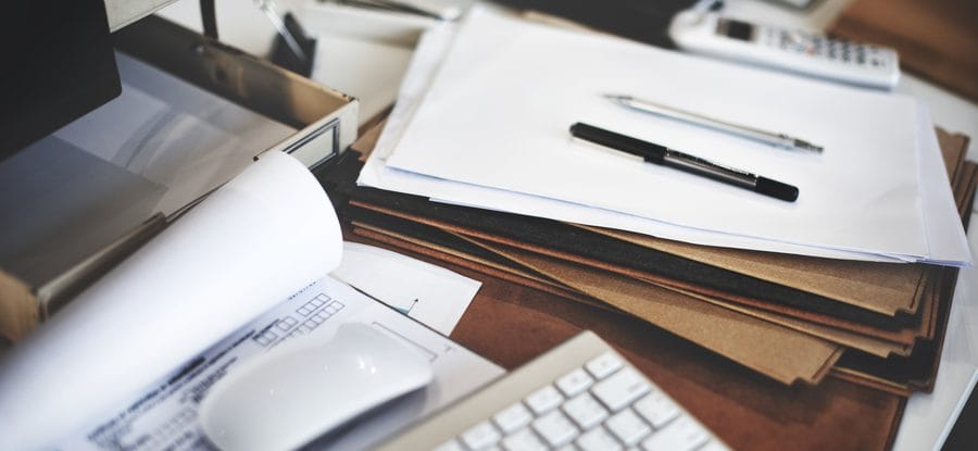 Documents administratifs et stylo sur un bureau, illustrant le solde de tout compte et les documents de fin de contrat